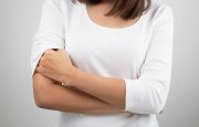 A woman scratching her arm